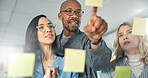Team, glass board and business people brainstorming, pointing at sticky notes with project ideas, schedule and agenda. Collaboration, problem solving and coworkers in planning meeting in workplace