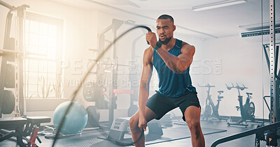 Buy stock photo Gym, fitness and black man with battle rope for muscle growth, strength development and power exercise. Equipment, endurance and African bodybuilder with resilience in workout, challenge or hard work