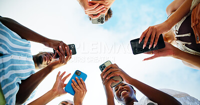 Buy stock photo Below, hands and people with smartphone, outdoor and smile with connection, social media and internet. Blue sky, low angle and friends with closeup, cellphone and tech for message, texting and group