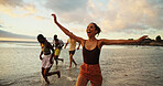 Sunset, running and friends in ocean water for freedom, vacation and summer trip on tropical island. Group, sea and people race by beach with energy for holiday, travel and excited for adventure