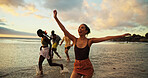 Holiday, running and friends in ocean water for freedom, vacation or summer celebration on island. Group, sea and people race at beach for energy to travel, splash or excited on adventure at sunset