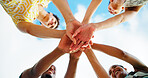 Friends, hands stack and low angle with sky, smile and support with motivation, diversity and cheers. People, group and happy with celebration, reunion and excited in nature, outdoor and vacation