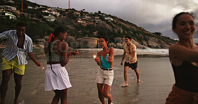 Buy stock photo Smile, friends and dance with sparkler on beach for travel celebration, freedom and summer holiday. Excited, people and fireworks for vacation achievement, tropical gathering an getaway for New Years