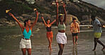 Happy, friends and walk with sparklers on beach for travel celebration, freedom and summer holiday. Excited, people and fireworks for vacation achievement, tropical gathering an getaway for New Years
