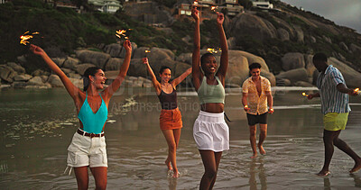Buy stock photo Happy, friends and walk with sparklers on beach for travel celebration, freedom and summer holiday. Excited, people and fireworks for vacation achievement, tropical gathering an getaway for New Years