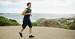 Beach, running and man in street, fitness and training with cardio, energy and challenge. View, person and runner with exercise, outdoor and sports with wellness, practice and healthy with ocean