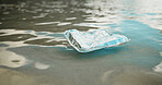 Food, ocean and dirt with pollution for recycling, climate change or global warming in nature. Empty, sea or garbage with foil container, litter or mess in water for waste management or contamination
