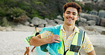 Portrait, beach and man with trash bag, volunteer and confidence with climate change. Face, happy person or activist with vest, ocean or plastic collection with environment, ecology or sustainability