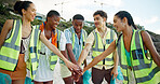 Happy people, volunteer and beach with hands together for community service, recycling or mission in nature. Group, social workers or team piling with stack for duty, global warming or climate change