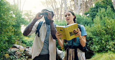 Buy stock photo Binoculars, travel and people with birdwatching in forest, book for info and knowledge of species in nature. Friends, man and woman with sightseeing, exploring and trekking with animal text in woods