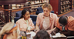 Research, college and books with students in library for assignment, friends and study group. University, learning and teamwork with people talking on campus for knowledge, future and project