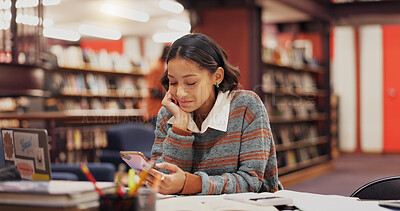 Buy stock photo Woman, student and phone at library, texting and happy with results, notification or chat at college. Girl, smartphone and click on mobile app for education, research or study break with social media