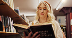 Woman, student and reading book in college library for learning, financial study and business course. Person, textbook and knowledge with investment information, education exam and university project