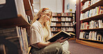 Student, reading book and floor in library for literature, research and studying for knowledge. Woman, relaxing and novel with academic information, scholarship and learning for education assignment
