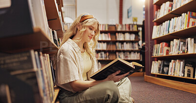 Buy stock photo Student, reading book and floor in library for literature, research and studying for knowledge. Woman, relaxing and novel with academic information, scholarship and learning for education assignment