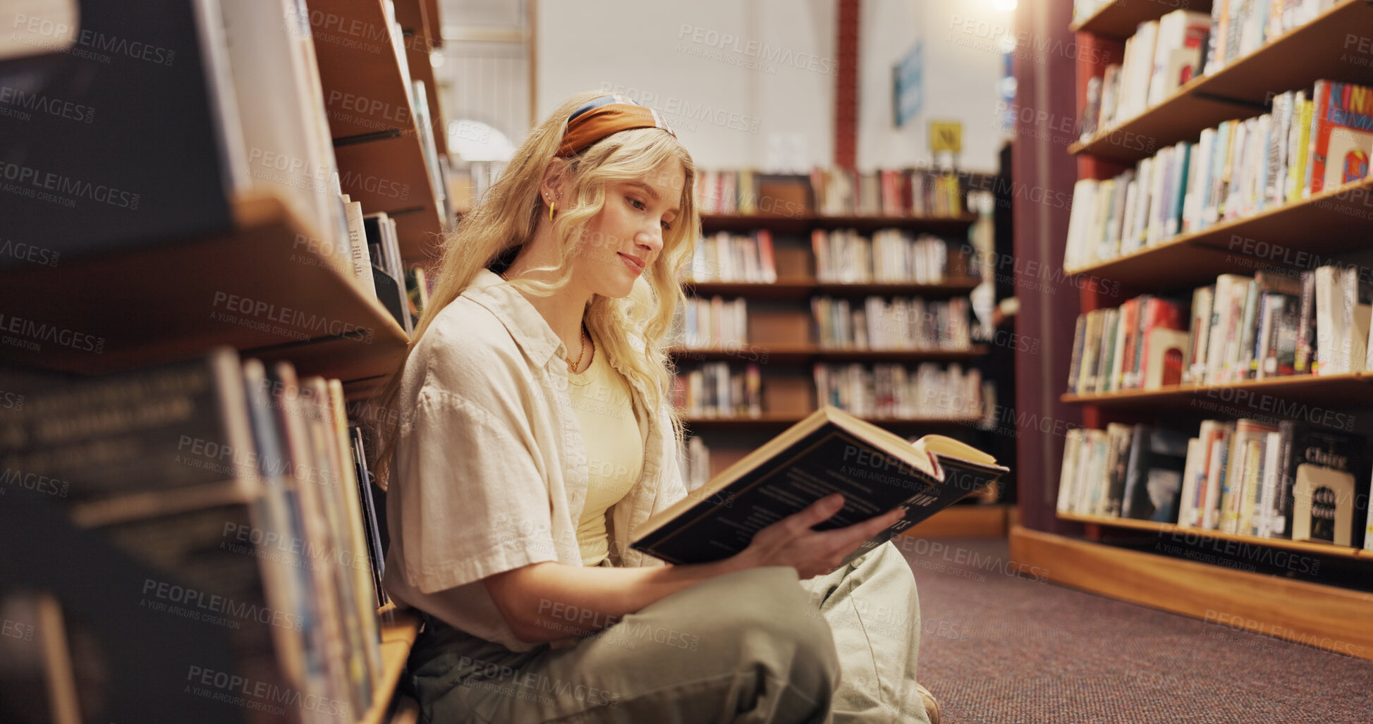 Buy stock photo Student, reading book and floor in library for literature, research and studying for knowledge. Woman, relaxing and novel with academic information, scholarship and learning for education assignment