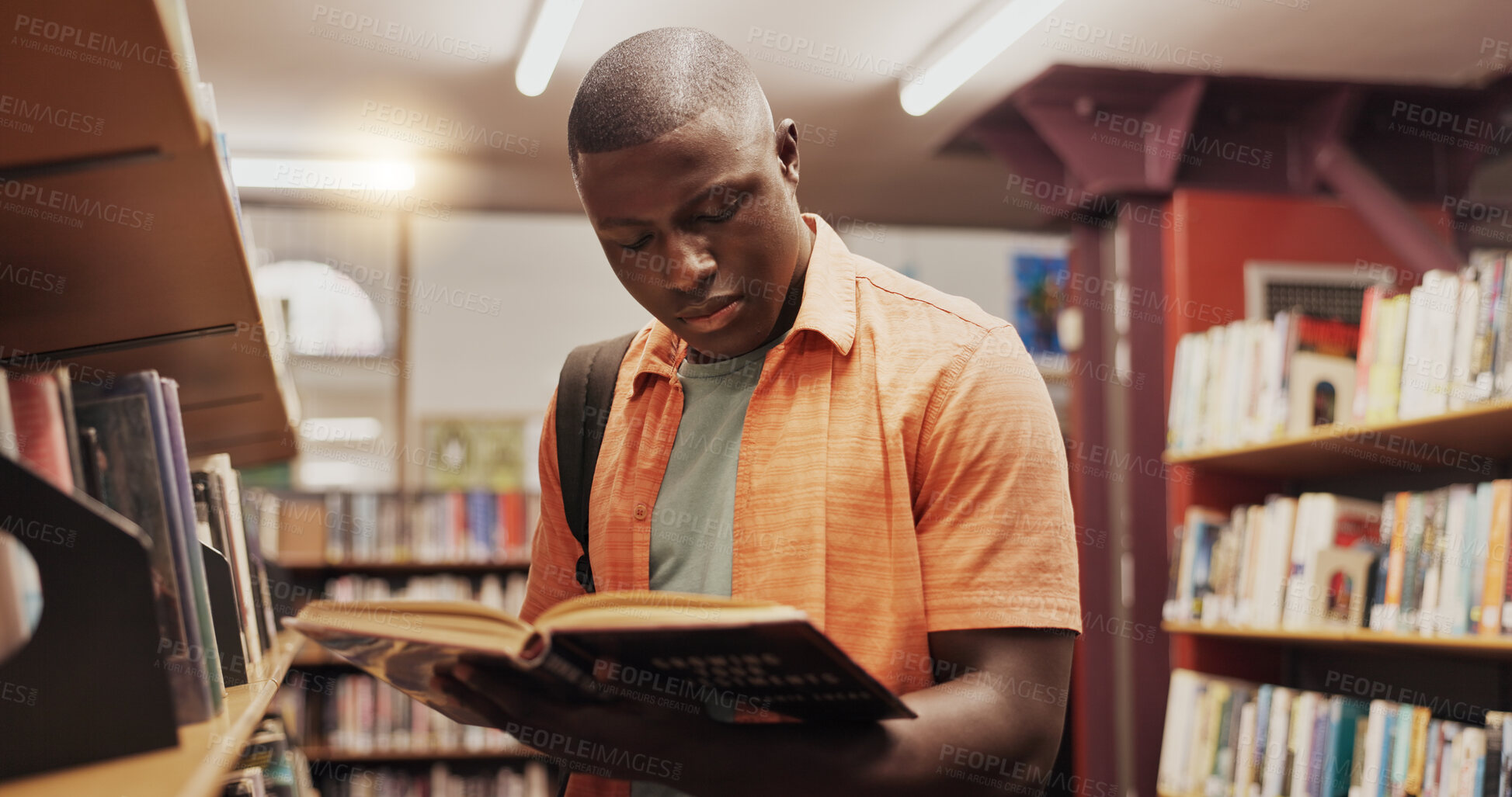 Buy stock photo Black man, reading and book as student in library for research, studying and exam preparation. Person, novel and literature information for knowledge, education and language assessment at university