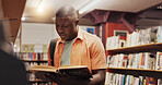 Black student, reading and book as man in library for research, studying and exam preparation. Person, novel and literature information for knowledge, education and language assessment at university
