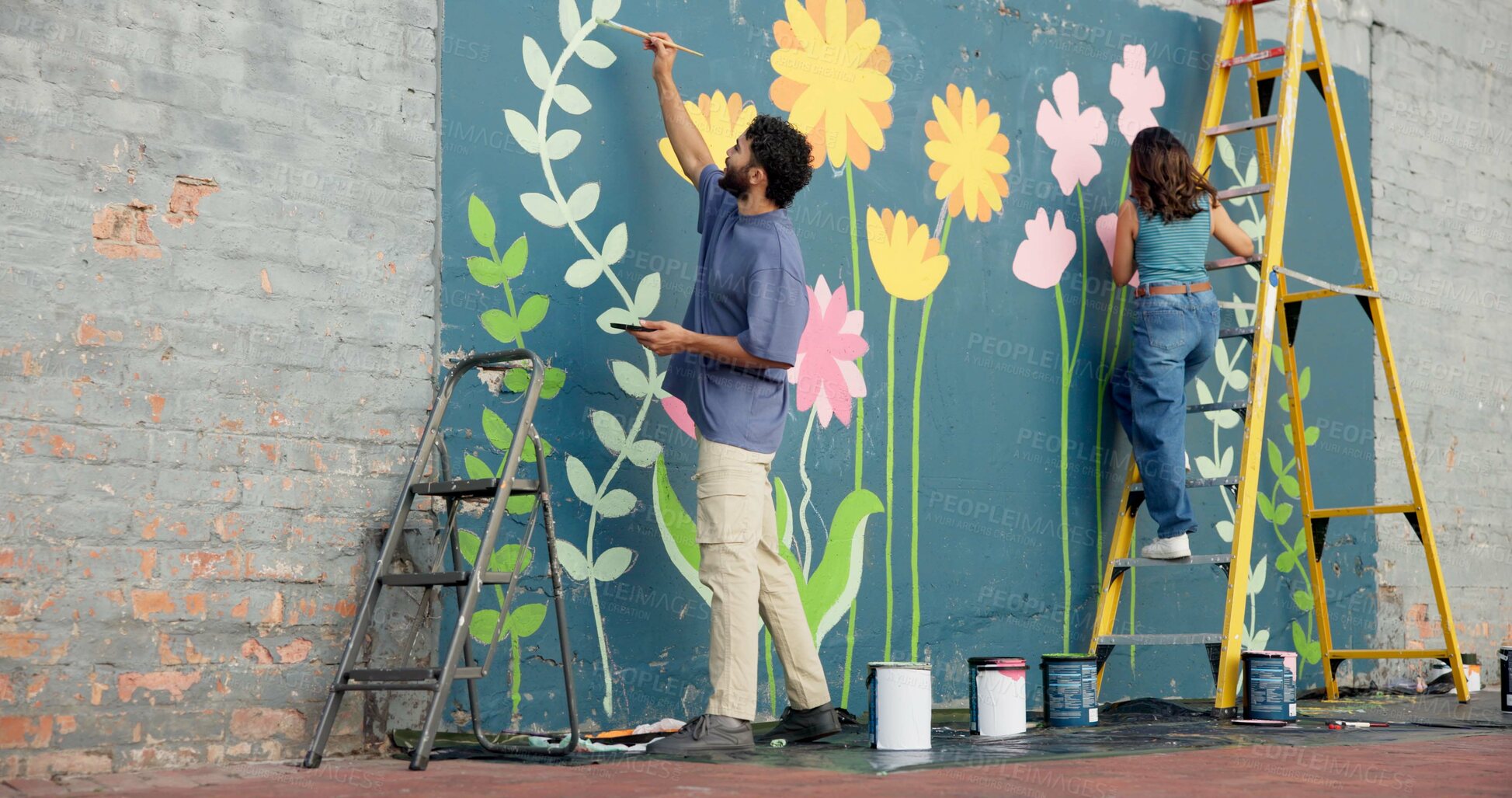 Buy stock photo Creative, couple and painting art on wall for project, mural design and renovation of community. Back, people and artist on ladder for improvement, diy decoration and makeover with flowers aesthetic