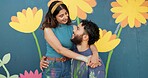 Hug, wall and couple with painting happy for art project, creative design and decoration outdoors. Renovation, smile and man and woman with inspiration for flowers, aesthetic or diy makeover together