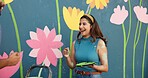 Couple, play and painting for wall art, mural process, decoration design and community project. Creative, people and woman laughing with artist brush, flowers aesthetic and bonding of diy improvement