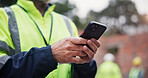 Phone, man and hands of construction worker on site with contact for renovation approval. Contractor, cellphone and closeup of male civil engineer reading building, maintenance or repairs online.
