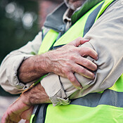 Hands, person and elbow pain with construction injury, work site ...