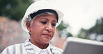Construction site, serious and woman with tablet, internet or communication with real estate. Mature person, employee or consultant with tech, stress or building development with property and helmet