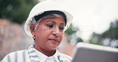 Buy stock photo Construction site, serious and woman with tablet, internet or communication with real estate. Mature person, employee or consultant with tech, stress or building development with property and helmet