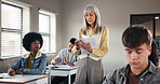 Exam, high school and teacher in classroom with test, paper and assignment for education. Woman educator, teenage students and quiz notes in academy for learning, growth assessment and development
