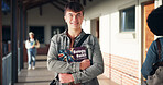Education, portrait and teenager smile with book in hallway for biology class, learning and study. Student, boy and happy at high school for bioscience knowledge, scholarship or development on campus