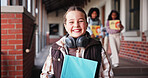Portrait, school and girl with book, smile and growth with education, child development and pride. Face, excited and children with knowledge, studying and confidence with academy and scholarship 