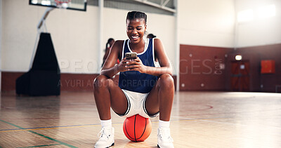 Buy stock photo Smile, basketball or black woman with phone in gym on social media on break in college game. Court, happy and African girl athlete with mobile app for workout, sports scholarship or fitness training
