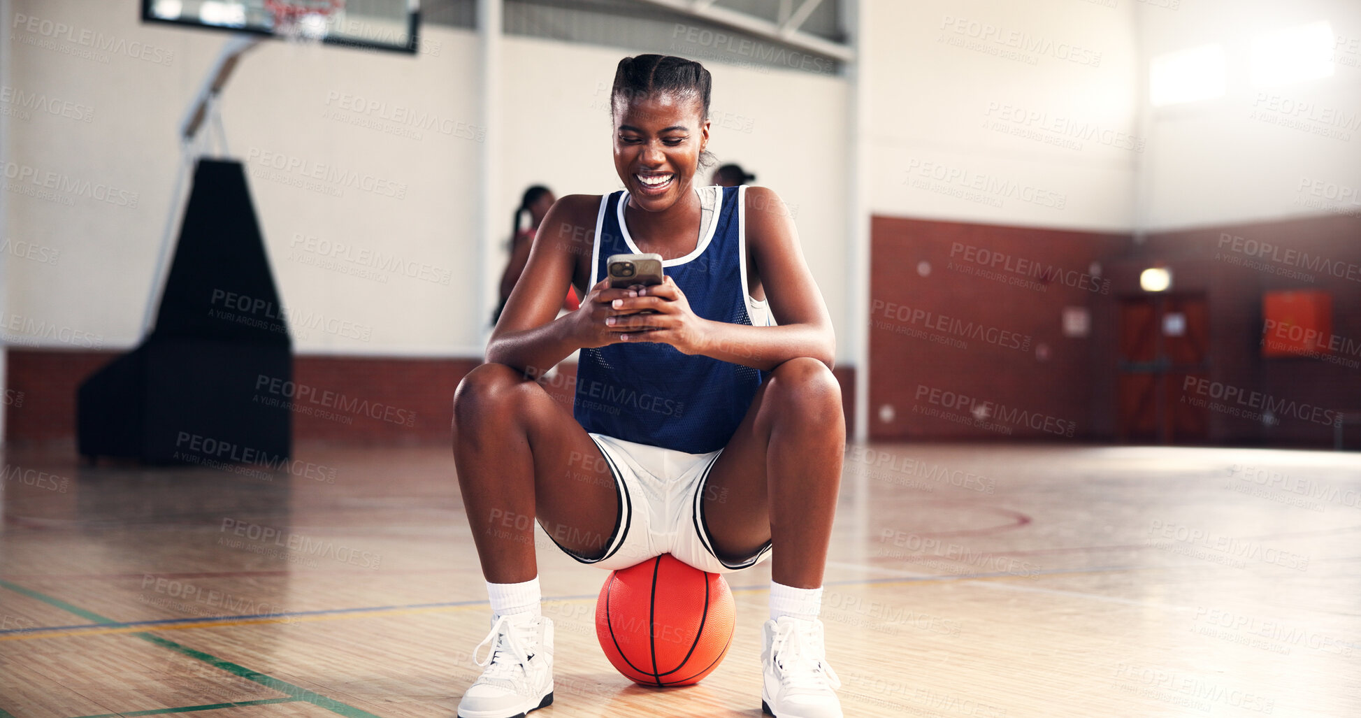 Buy stock photo Smile, basketball or black woman with phone in gym on social media on break in college game. Court, happy and African girl athlete with mobile app for workout, sports scholarship or fitness training