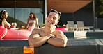 Happy, portrait and man in pool at party at vacation house for break with friends for travel. Smile, relax and male person swim in water at luxury home on holiday at lodge, resort or hotel in summer.