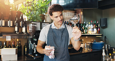 Buy stock photo Waiter, man and cleaning glass with cloth for hygiene, dust and service for drinks at restaurant. Person, bartender and check for dirt with smile, shine and career with inspection at small business