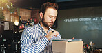 Coffee shop, boxes and man on tablet in cafe for menu items, inventory and order checklist. Restaurant, hospitality and business owner on digital tech for internet, planning and review on website