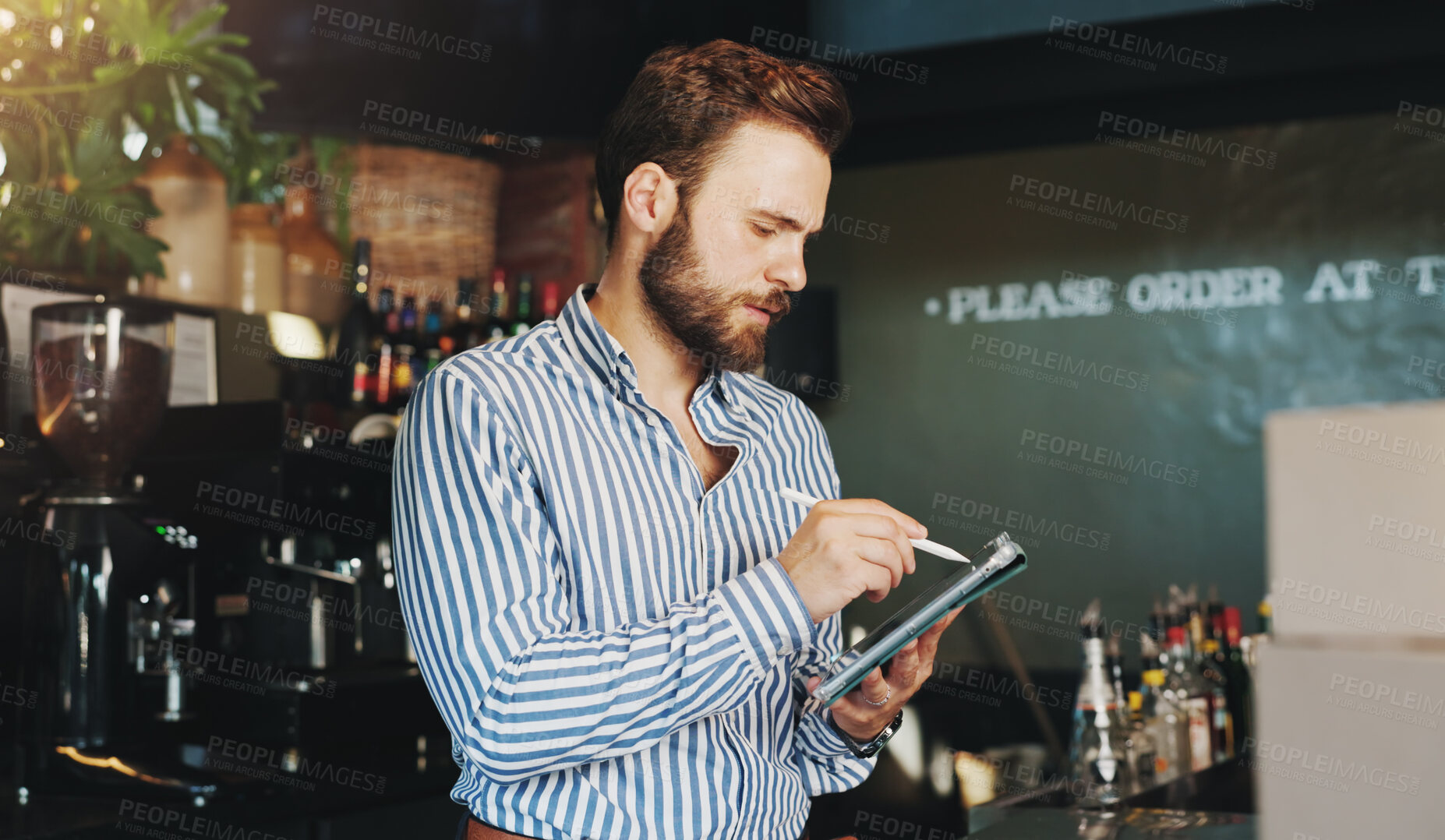 Buy stock photo Coffee shop, online and man on tablet in cafe for menu items, inventory and order checklist. Restaurant, hospitality and business owner on digital tech for internet, planning and review on website