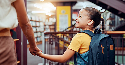 Buy stock photo Holding hands, person and child in library, education and walking with student, smile and backpack. Happy, growth and development of kid with knowledge, learning and teacher with girl in school