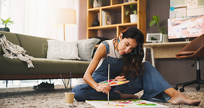 Buy stock photo Home, painting and woman on carpet, creative development and freelance designer with artistic expression. Mature person, relax and painter on floor, brushes and canvas with  abstract project or ideas