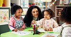 Drawing, helping and teacher with children in classroom for education, nursery and creative art. Growth, kindergarten and academy with woman and kids at school for learning and child development