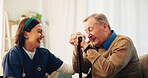 Home, funny and nurse with senior man, smile and laughing with happiness, bonding together and joke. Pensioner, old person and caregiver with comedy, cheerful and support with humor, relax and trust