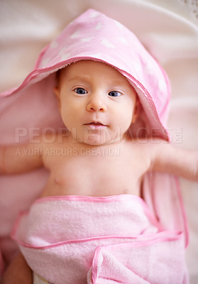 Buy stock photo Baby, face or kid in hooded towel on bed for bathing, hygiene or morning routine for healthy development. Infant, child or top view in nursery with washing for skincare, body care or wellness in home