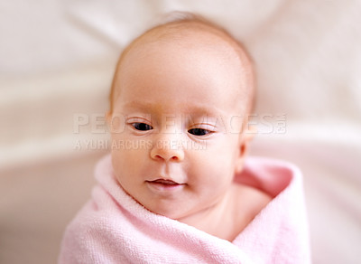 Buy stock photo Baby, face and child in towel on bed for bathing, hygiene and morning routine for healthy development. Infant, kid and top view in nursery with washing for skincare, body care and wellness in house