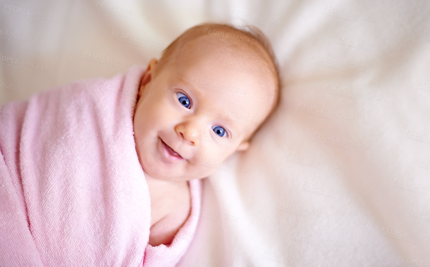 Buy stock photo Baby, face and towel on bed in home for bathing, hygiene and morning routine for healthy development. Infant, child and top view in nursery with washing for skincare, body care and wellness in house