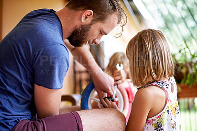 Buy stock photo Bicycle, repair and man helping kid in home with teaching, learning together and bonding with daughter. Maintenance, support and dad fixing bike wheel for girl with tools, care and child development