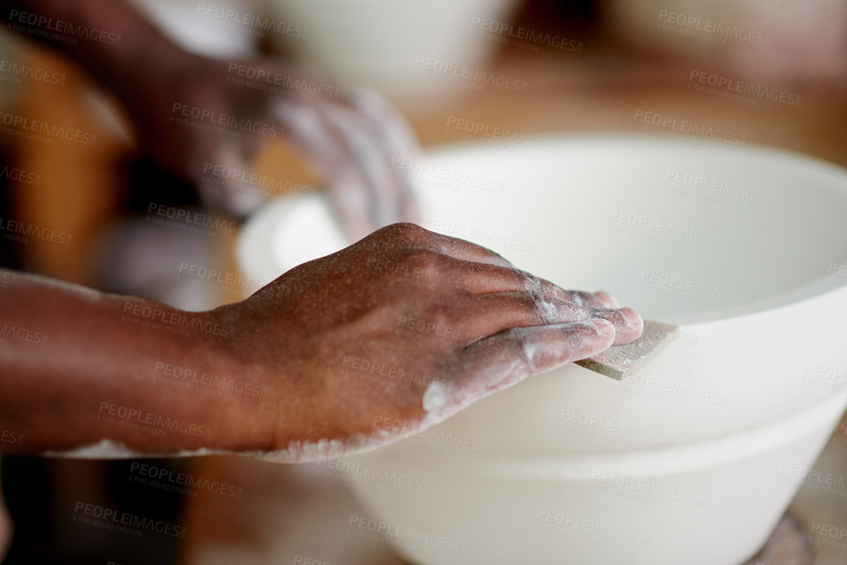 Buy stock photo Hands, person and sanding with clay for pottery sculpture, production process and craft design. Closeup, worker and equipment for manufacturing, smooth texture and ceramic artwork for small business
