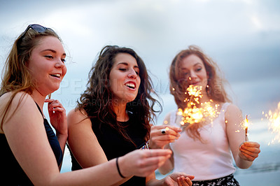 Buy stock photo Happy, outdoor and girl friends with sparklers for celebration, party or social gathering at event. Bonding, fun and women with fireworks for spring break festival, holiday or vacation together.