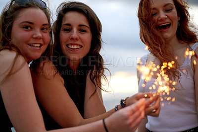 Buy stock photo Happy, sparklers and portrait of girl friends outdoor for celebration , party or social gathering. Smile, fun and female students with fireworks for bonding on holiday, vacation or travel together.