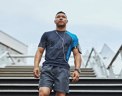 Buy stock photo Fitness, thinking and man in city with earphones, health and wellness on steps for outdoor training. Urban workout, body care and runner listening to music, podcast or morning exercise on stairs